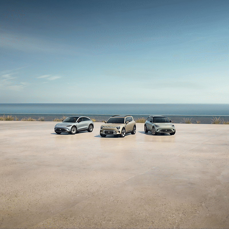 Zwei smart Autos vor einem minimalistischen Gebäude mit Bäumen im Hintergrund.