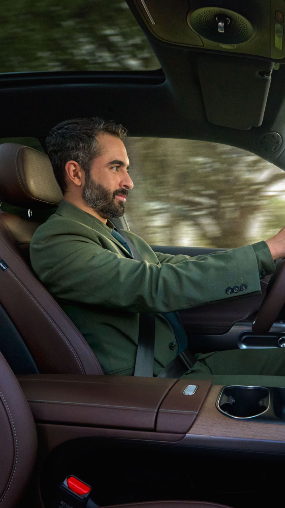Un uomo è seduto al volante di una smart #5, sullo sfondo si intravedono degli alberi.